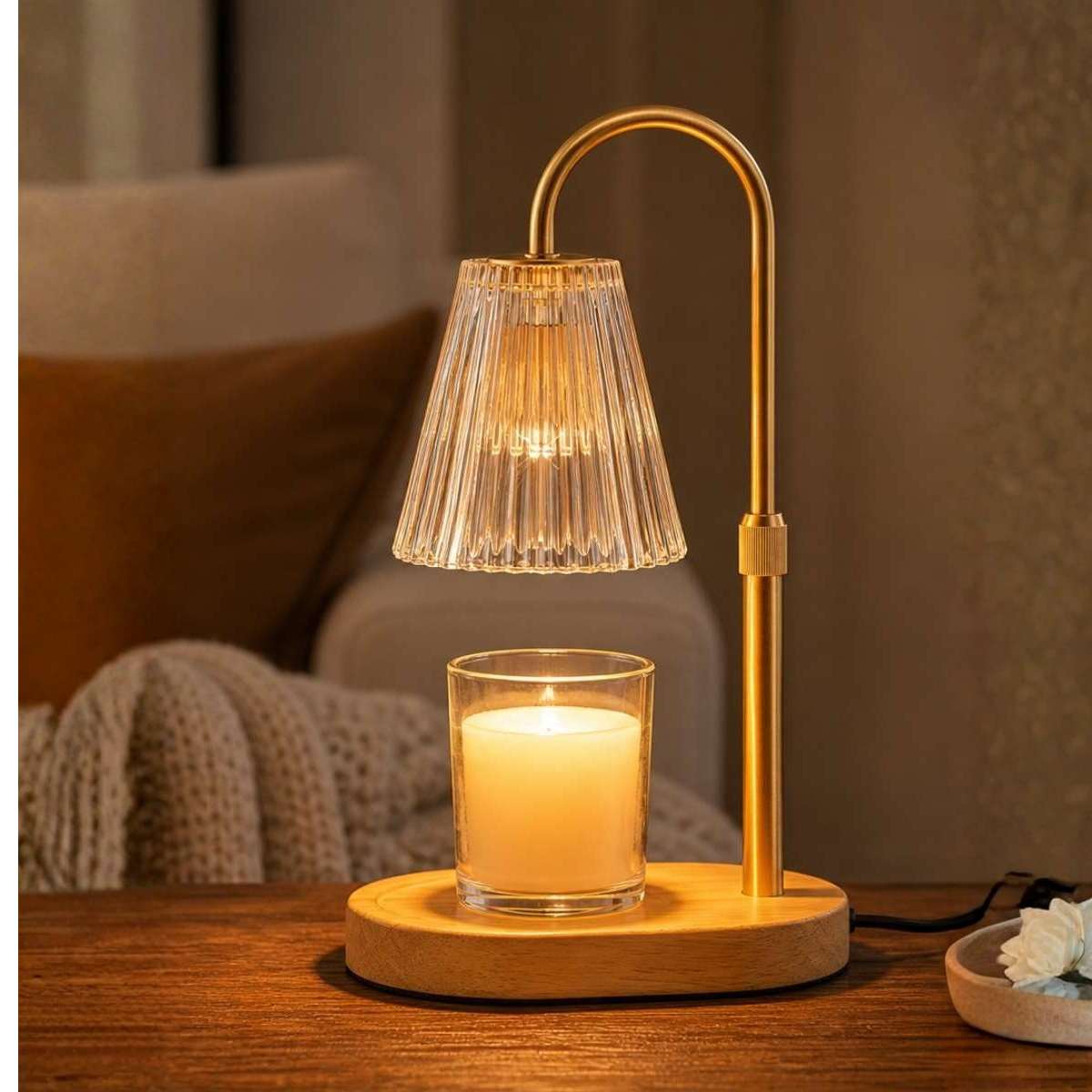 Amber glass candle warmer lamp creating soft evening lighting beside a bed