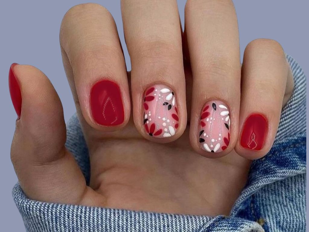 spring nail design with red polish and floral accents